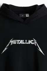 Canguro negro con capucha, bolsillo tipo canguro y logo de la banda Metallica estampado en el frente.