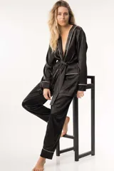 Pijama de satén color crema con ribetes negros, compuesto por un kimono con lazo y pantalones rectos.