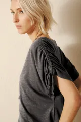 Remera gris de jersey flamé con cuello redondo y mangas cortas con cordones ajustables.