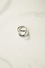 Anillo plateado de acero quirúrgico con diseño irregular y ajustable.