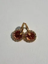 Par de aros dorados con dije circular de resina color terracota con glitter y borde de strass.