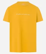 Remera de hombre color mostaza, de corte comfort, con cuello redondo y manga corta. Estampa frontal con la frase "La confiance est le secret du succès" en color blanco.