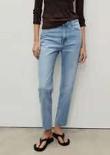 Jeans celeste de tiro alto, corte mom fit, con cinco bolsillos y cierre frontal con cremallera y botón.