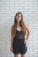 Vestido negro de fiesta, corte mini, con top tipo corsé con costuras fruncidas y breteles finos que se atan en la espalda. Elástico en la cintura trasera.