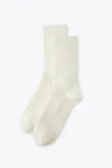 Calcetines largos color crema de tejido de punto acanalado.