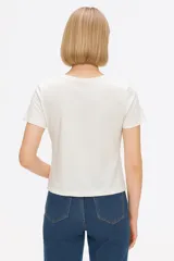 Remera negra de manga corta con estampado frontal que incluye la palabra "Believe" en letras doradas con efecto foil y un diseño abstracto con patrones de cebra y piel de animal.