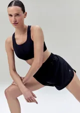 Short deportivo negro, de tela liviana y brillante, con cintura elástica fruncida y corte redondeado en el ruedo.