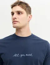 Remera azul marino de algodón con cuello redondo y estampado frontal con la frase "All you need" en color celeste.