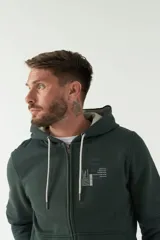 Campera de felpa color gris claro, con capucha ajustable con cordones, cierre frontal y bolsillos tipo canguro.