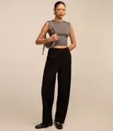 Blusa cropped de microfibra color marrón, sin estampa, con cuello redondo, breteles anchos, espalda abierta y bajo retorcido.