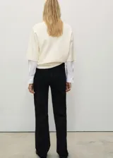 Pantalón de jean negro de corte recto, tiro medio y largo hasta el tobillo.