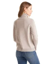 Polera tejida en hilado fino color verde oscuro, de manga larga con tajo en el puño y cuello alto.