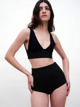 Top de bikini negro de tejido italiano con protección UV+50, de corte clásico y calce adaptable.