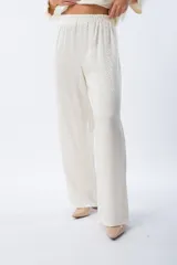 Pantalón palazo blanco con estampado animal print, cintura elastizada y lazo ajustable.