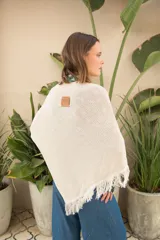 Poncho tejido en hilo de algodón con lurex color negro y dorado, con flecos en el ruedo.