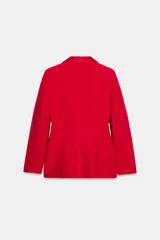 Blazer roja de corte recto, con cuello smoking de satén negro, mangas largas con hombreras, bolsillos frontales con solapa y cierre frontal con un botón.