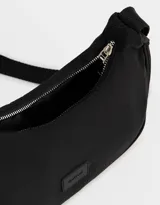 Bandolera tipo baguette de tela deportiva color negro con asa de hombro y cierre superior.