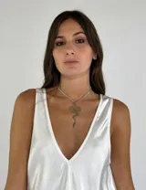 Collar dorado con dije en forma de serpiente y cordón fino color beige.