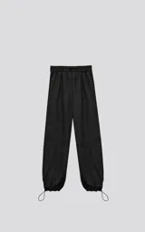 Pantalón negro de corte holgado con bolsillos laterales y cintura elástica ajustable con botón y cierre.