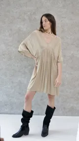 Vestido corto color beige, de raso, con escote en V y mangas 3/4. Corte holgado.