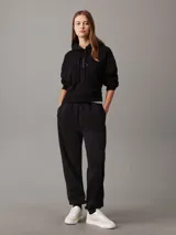 Pantalón de chándal negro de felpa de mezcla de algodón reciclado, corte regular, cintura elástica con cordón interior, puños de punto, bolsillos en la costura lateral y bordado en relieve Calvin Klein en la parte superior de la pierna.