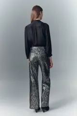 Pantalón oxford de cuero ovino con estampado reptil multicolor y detalles metalizados. Tiro alto, cinco bolsillos y pierna ancha desde la cadera.