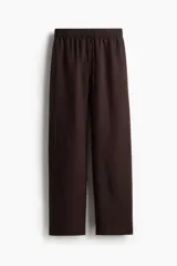 Pantalón marrón de corte holgado en tejido liviano de mezcla de lino. Modelo de tiro alto con cintura elástica y cordón para ajustar fino, bolsillos laterales discretos y piernas rectas.