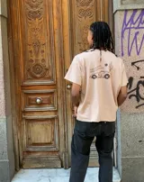 Remera color chocolate con estampado trasero de un auto, un cactus, una estrella de sheriff y la frase "Save a horse, ride a ferrari".
