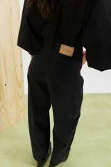 Pantalón de jean negro de corte amplio, con tiro alto y detalles de costuras en las piernas.