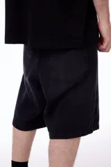 Bermuda de gabardina negra con bordado de la marca "blkmba" en el frente, tiro bajo y bolsillos traseros y laterales.