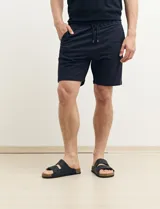 Bermuda de gabardina color gris oscuro, corte recto y largo a la rodilla.