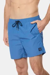 Short de baño azul vibrante, de corte clásico y largo medio, con cintura elástica y cordón ajustable. Cuenta con bolsillos laterales y suspensor de malla fina interior.