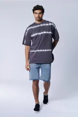 Remera gris oscuro con diseño tie dye de rayas horizontales blancas.