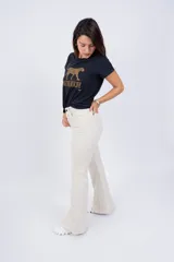 Pantalón Oxford color crema con corte acampanado y aberturas en el ruedo.