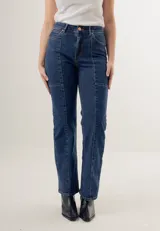Pantalón de jean azul oscuro, de corte recto y tiro alto, con bolsillos delanteros y traseros. Presenta costuras verticales en el frente.