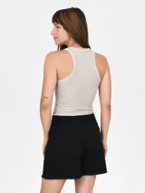 Musculosa negra ajustada al cuerpo, con cuello redondo y diseño de tirantes anchos tipo halter.