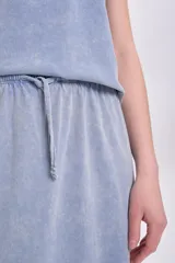 Falda midi celeste con efecto lavado, cintura elastizada con cordón ajustable y tajo lateral.