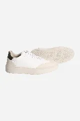 Zapatillas urbanas blancas con detalles en cuero color crema y talón en cuero verde oscuro.