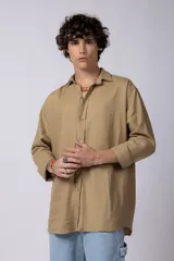 Camisa color arena de lino, manga larga, con cuello clásico y corte holgado.
