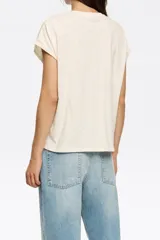 Remera color crema con estampado del logo de la marca Bimba y Lola en color naranja. Corte clásico y mangas cortas.