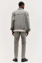 Pantalón de jean gris con efecto lavado, corte regular tapered, tiro medio, cinco bolsillos y cierre con botón y cremallera.