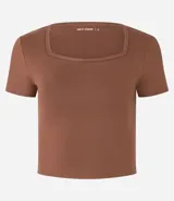 Remera deportiva cropped azul marino, confeccionada en microfibra suave, con escote cuadrado y mangas cortas.