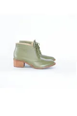 Botines de cuero color verde oliva con cordones frontales y tacón bloque de madera clara.