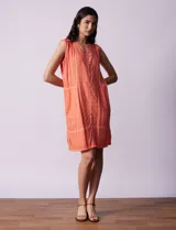 Vestido de algodón texturado color naranja, con cuello en V y sin mangas.