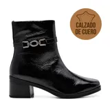 Bota corta de cuero color marrón, con taco bajo y punta cuadrada. Presenta una correa con hebilla dorada alrededor del tobillo.