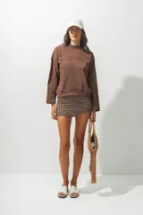 Buzo rojo de cuello alto con la palabra 'Rotunda' bordada en el frente. De corte holgado y mangas largas.