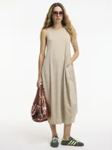 Vestido midi negro de silueta balloon con bolsillos laterales y mezcla de texturas en laterales y frente.