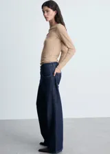 Camiseta color beige de tejido de punto acanalado, corte entallado, cuello barco y mangas largas.