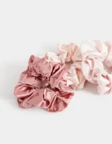 Set de tres scrunchies de satén en tonos rosa y beige.