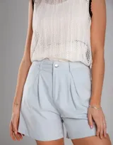 Short celeste de gabardina de algodón, tiro alto, corte amplio, pinzas frontales, bolsillos laterales, cierre y botón metálico.